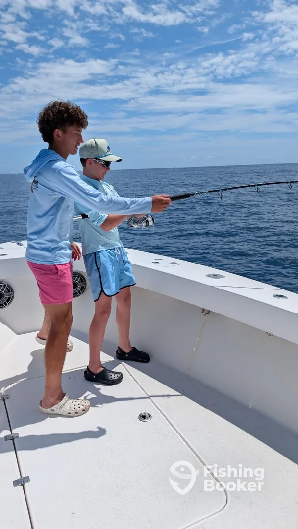 Young angler fighting a fish from the deck during an offshore trip