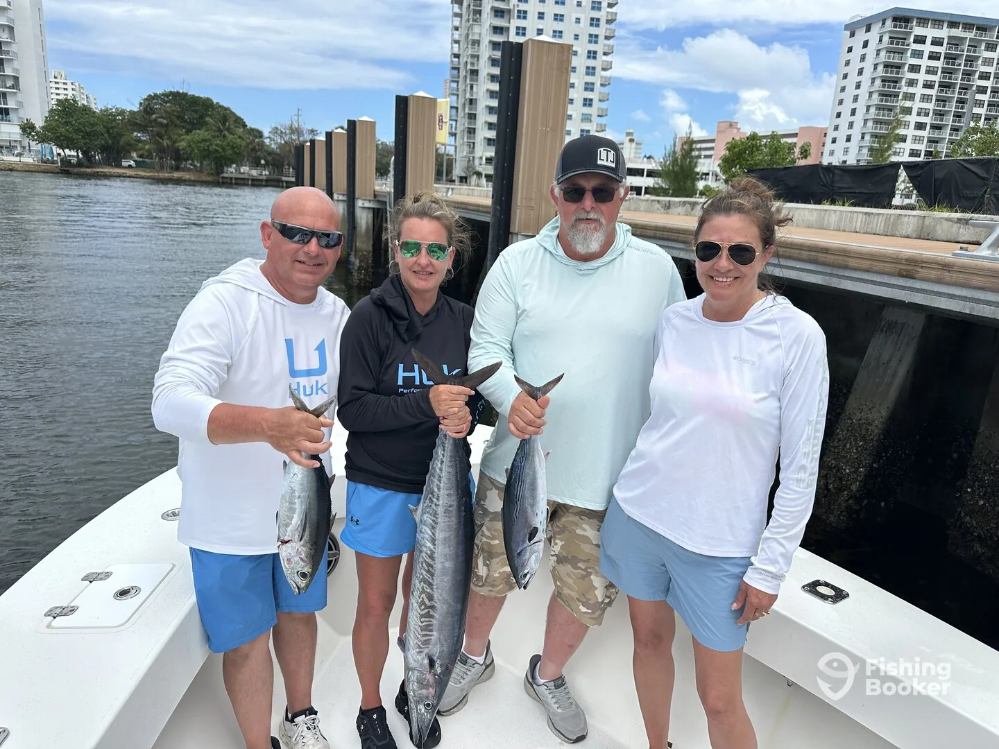 A party of four at the dock with their kingfish after a charter