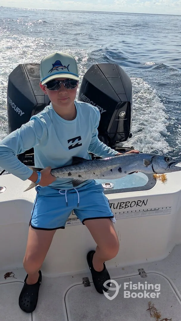 A king mackerel held over the wake on a Reel Stubborn charter
