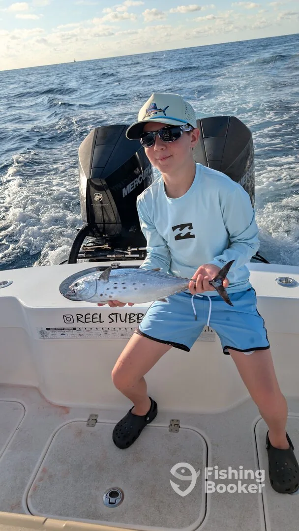 Young angler holding a fish caught offshore aboard Reel Stubborn