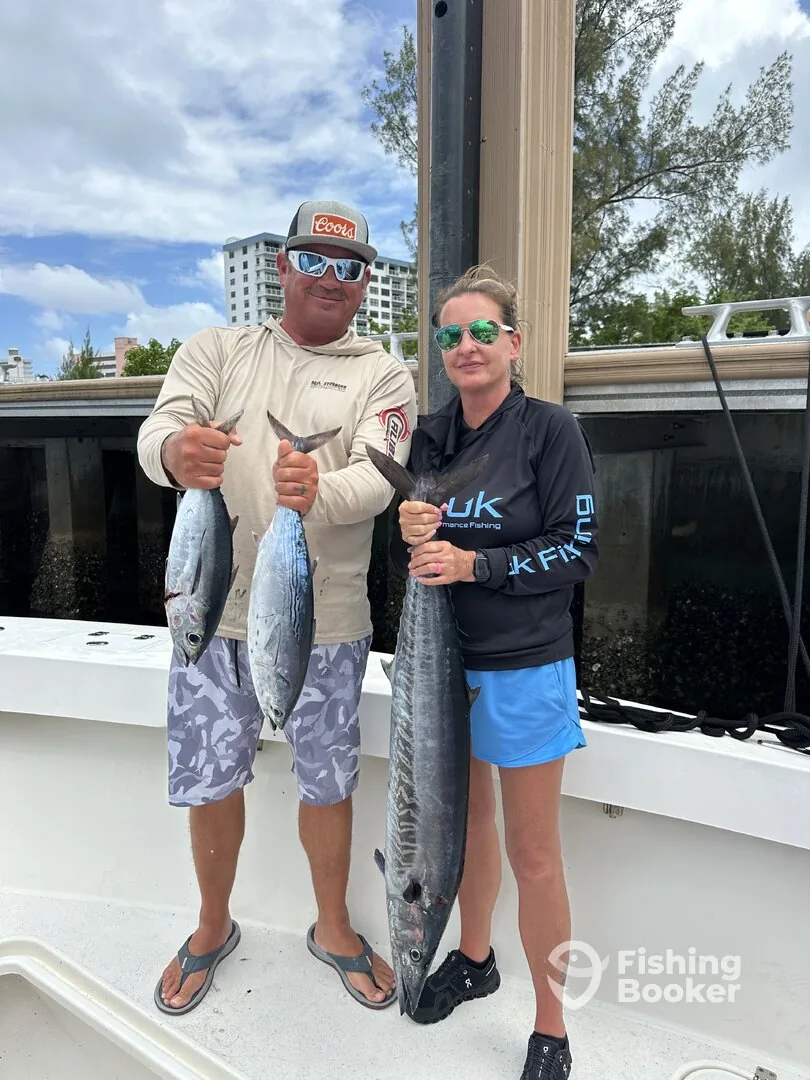 Two anglers holding a wahoo at the Pompano Beach dock